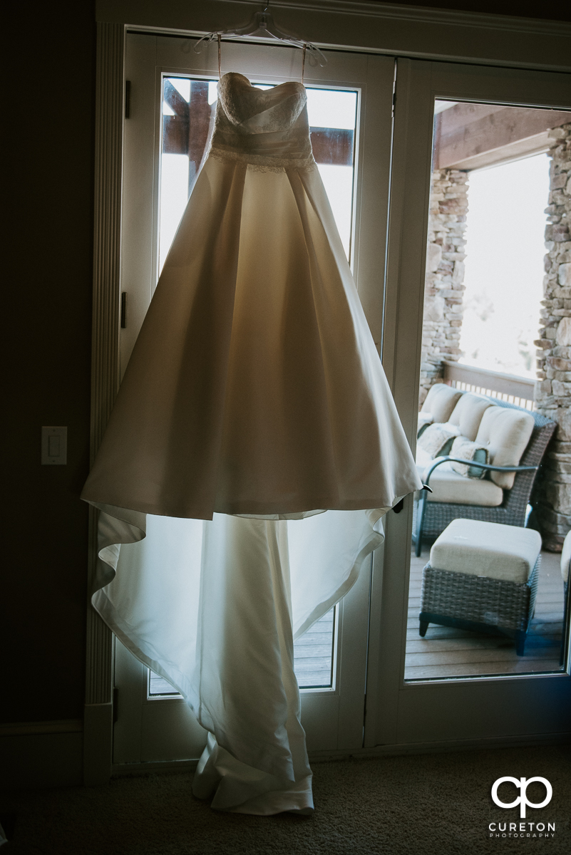 Bride's dress hanging up in a window.