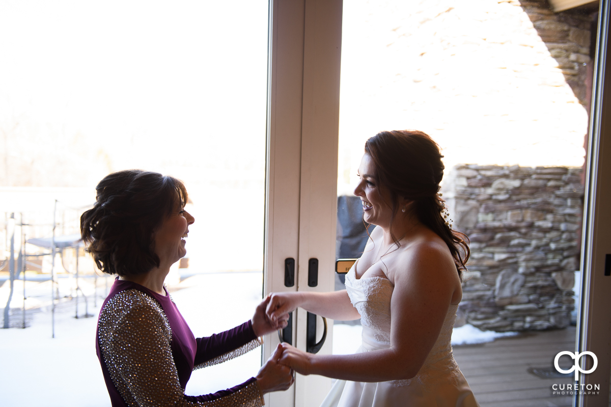 Bride and her mother in front of the window before the ceremony.