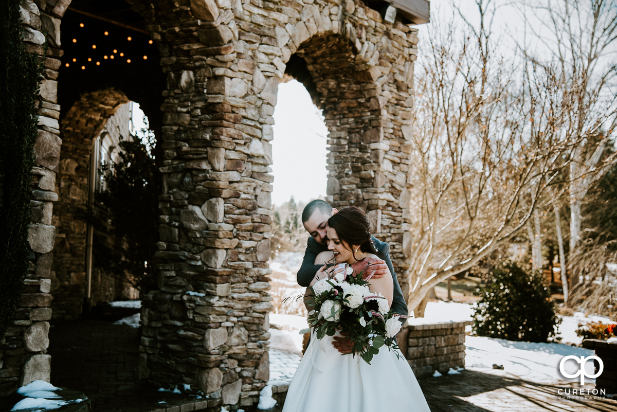Bride and groom cuddling in the snow before their Cleveland NC wedding at The Arbors.