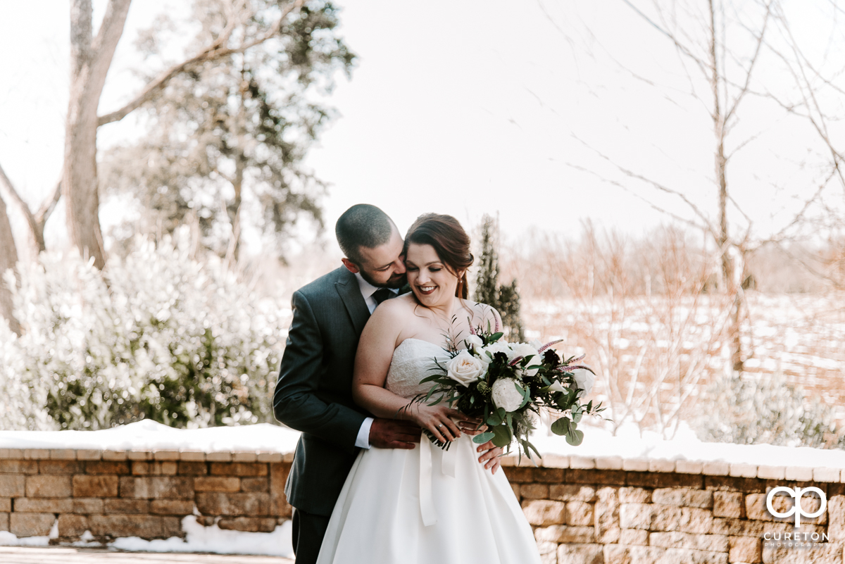 Bride and groom getting close in the snow before their wedding near Lake Norman.