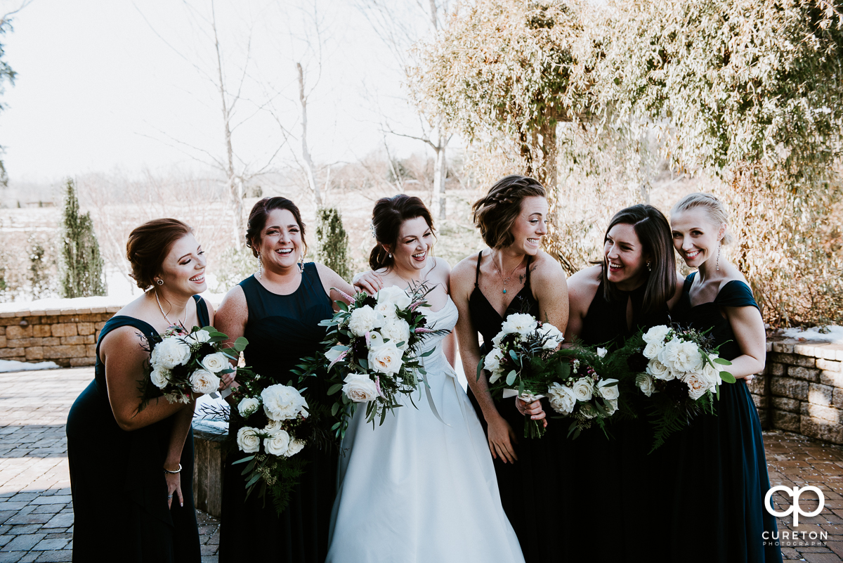 Bride laughing with her bridesmaids.