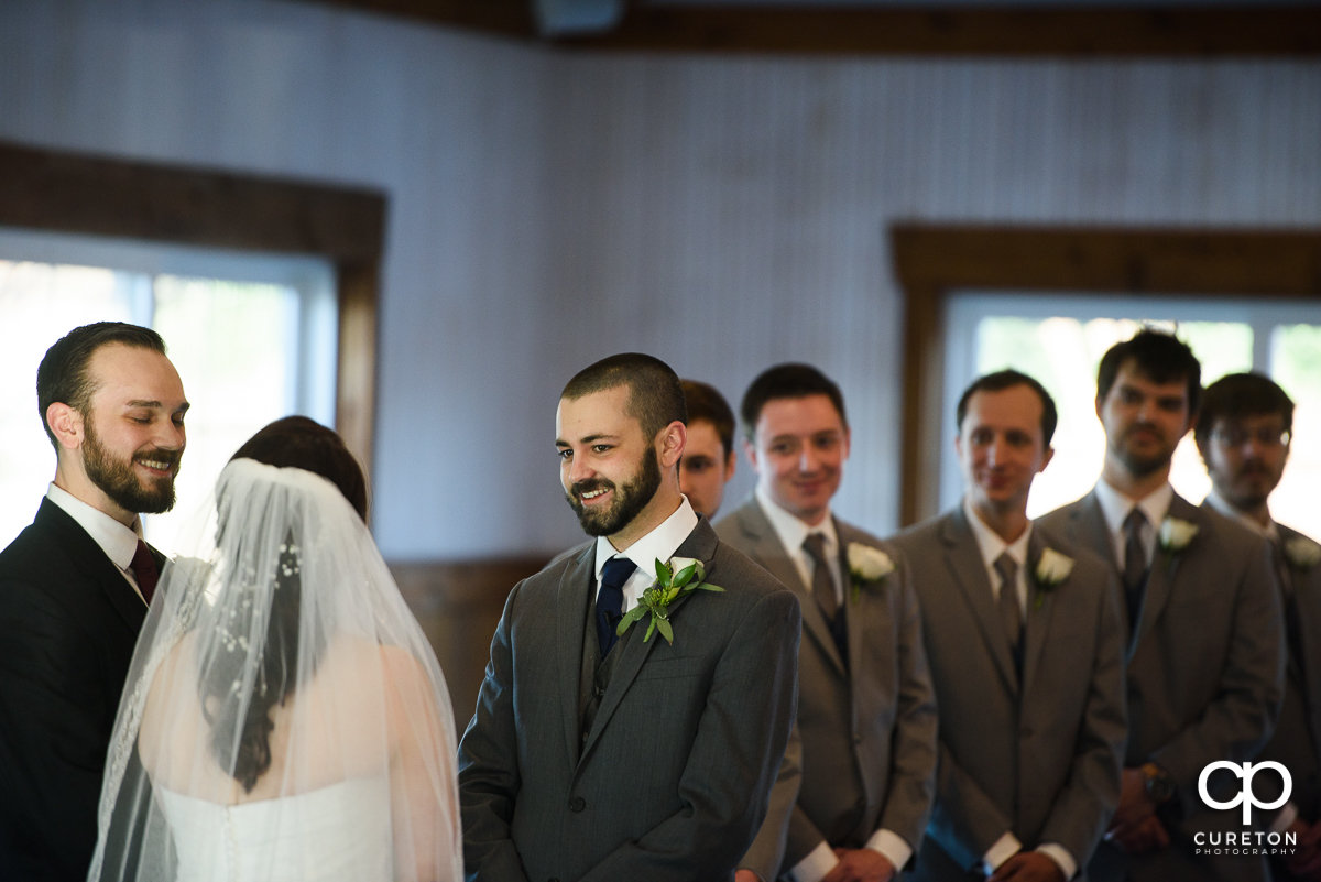 Groom smiling at the bride during the ceremony.