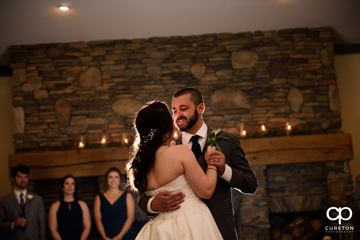 Groom smiling during the first dance with his bride.