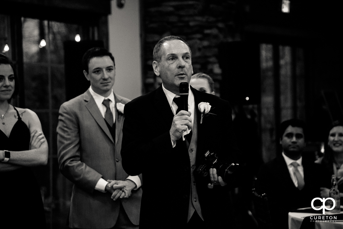 Bride's father holding the microphone.