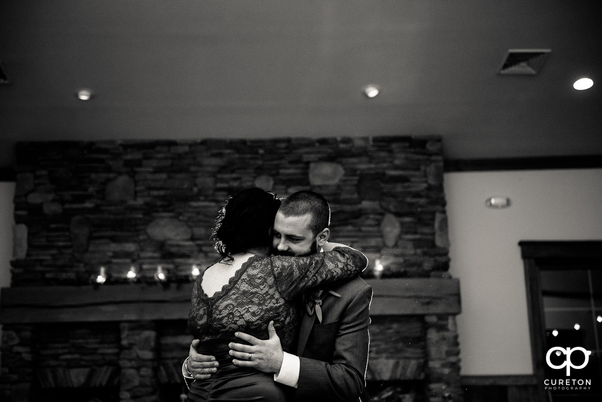 Groom getting a hug from his mom at the reception.