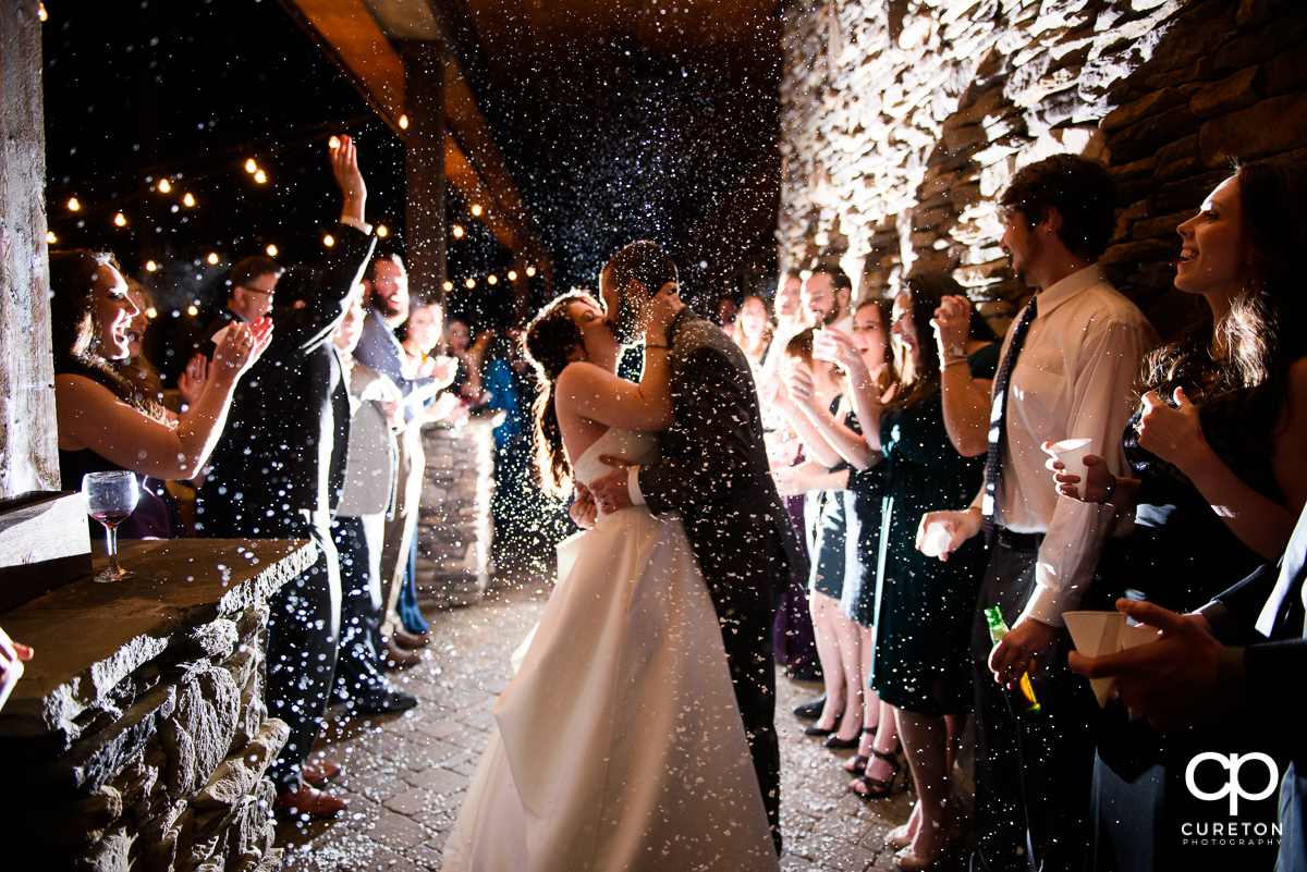 Married couple making a grand exit as the guests throw fake snow.