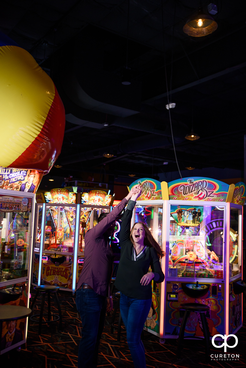 Couple dancing inside an arcade for their engagement session.