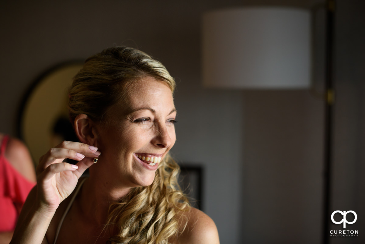 Bride putting on her earrings.