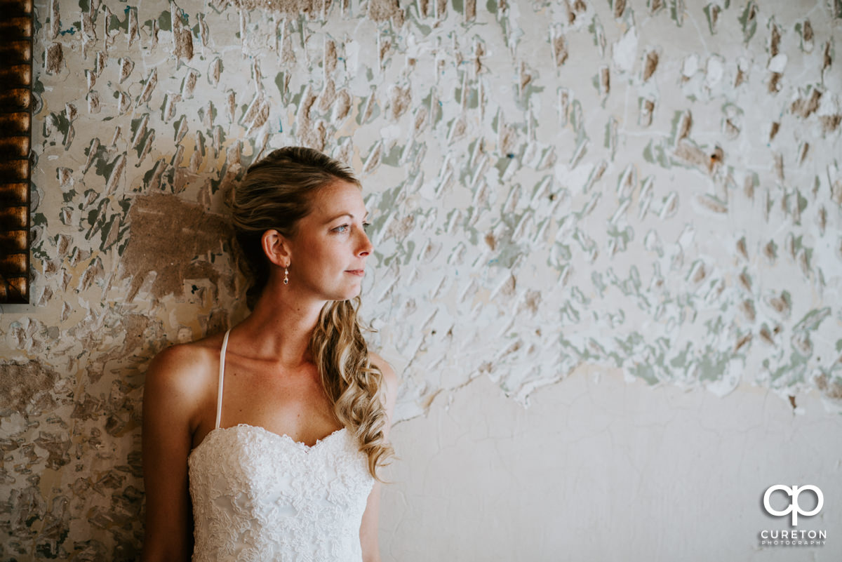 Bride looking out a window before walking down the aisle at her wedding ceremony.