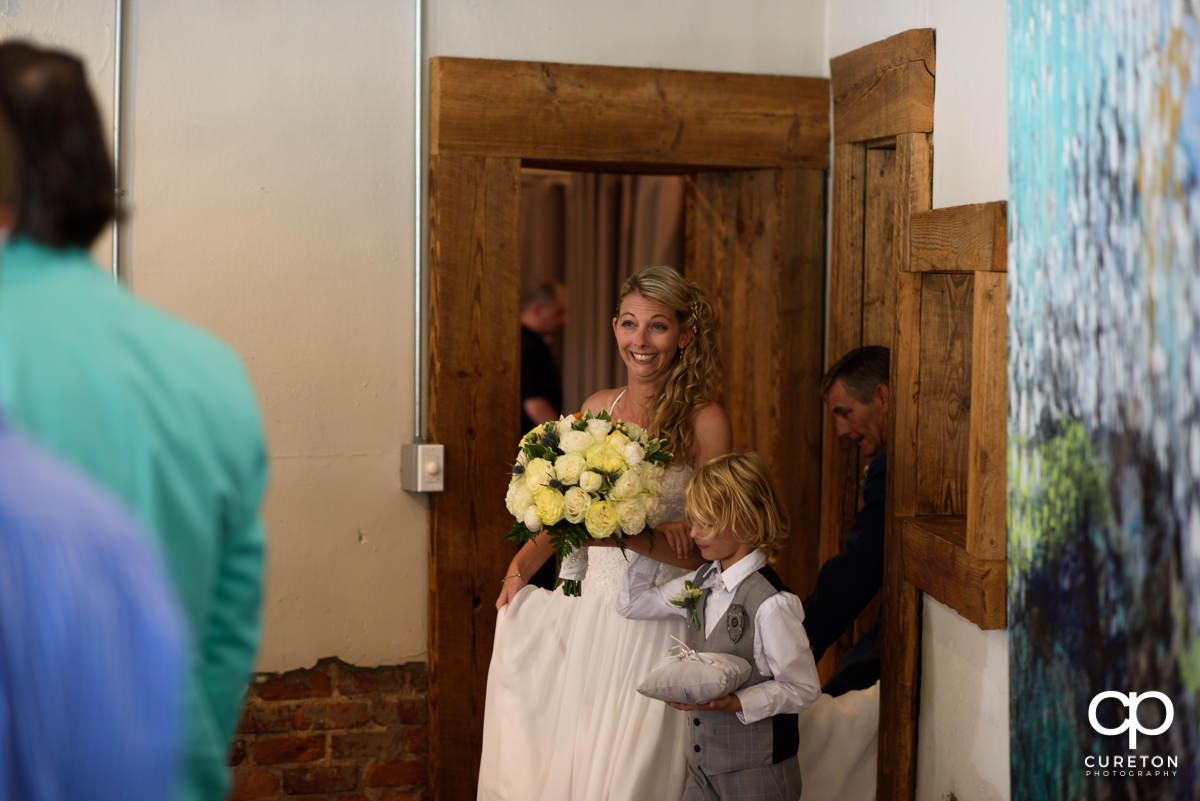 Bride walking down the aisle at her ceremony at Artisan Traders.