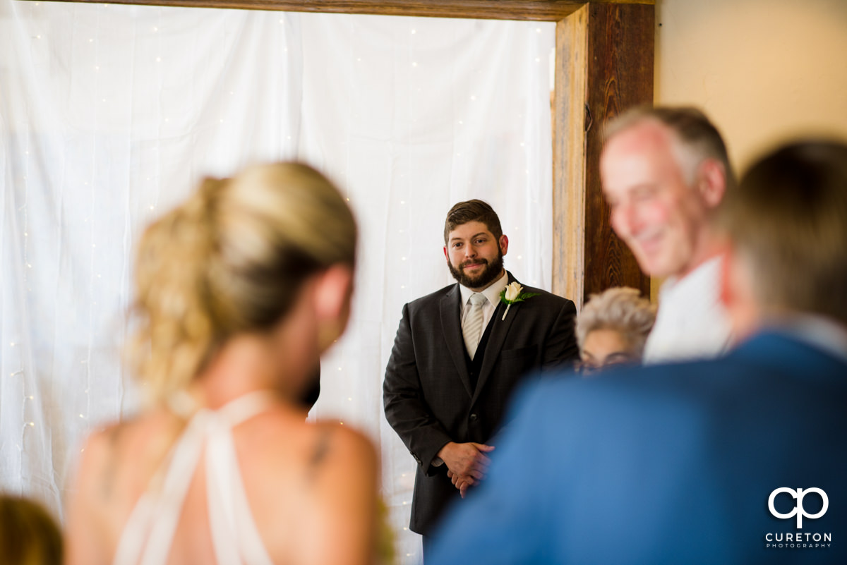 Groom seeing his bride walking down the aisle fo t he first time.