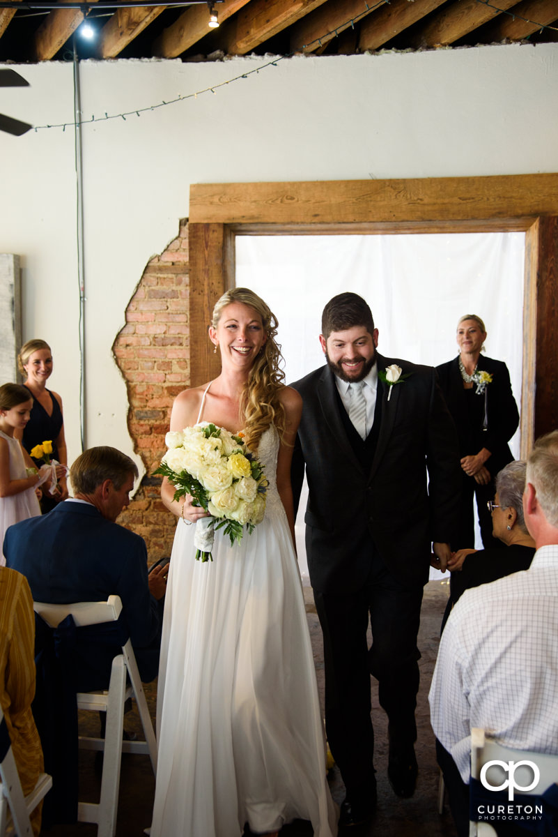 Bride and groom walking back down the aisle at their ceremony.