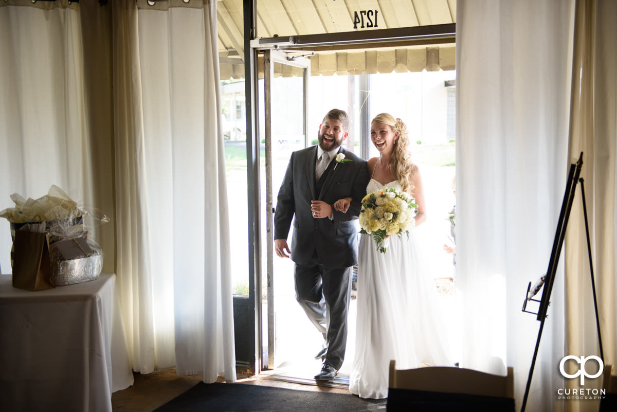 Bride and groom making an entrance at their reception at Artisan Traders.