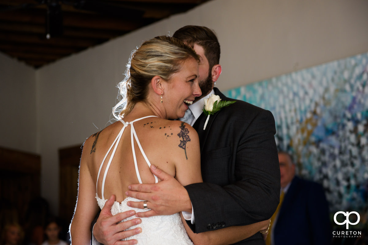 Bride laughing during their first dance.