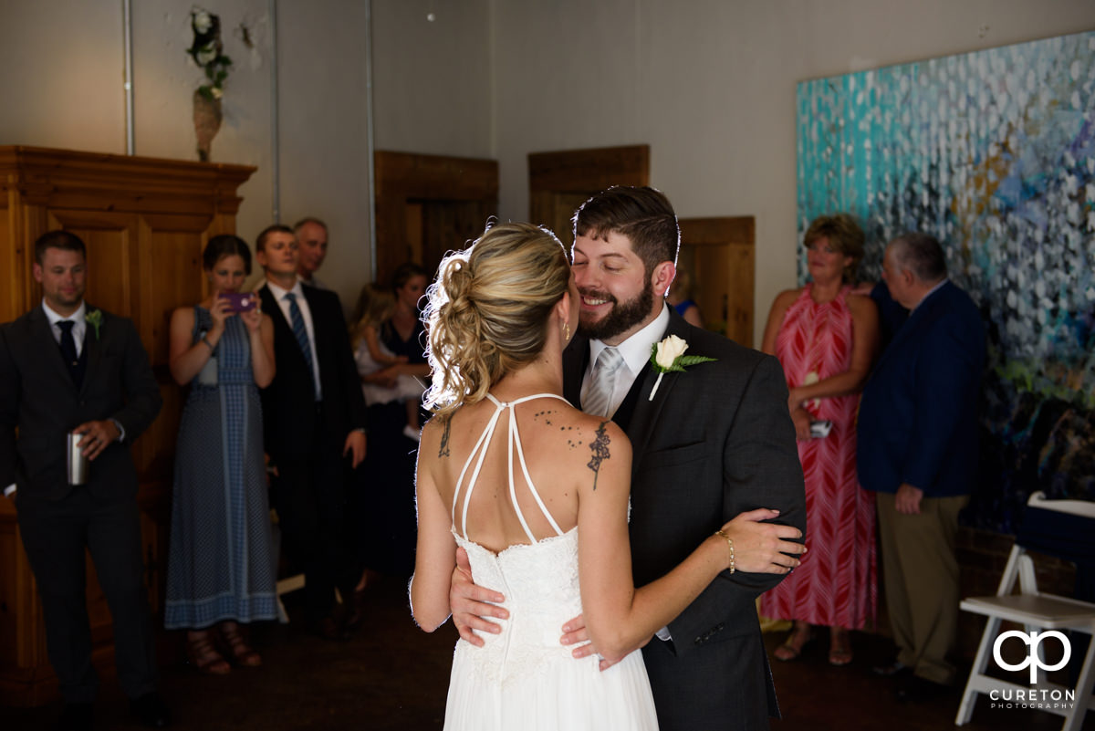 Groom smiling at his bride during their first dance.