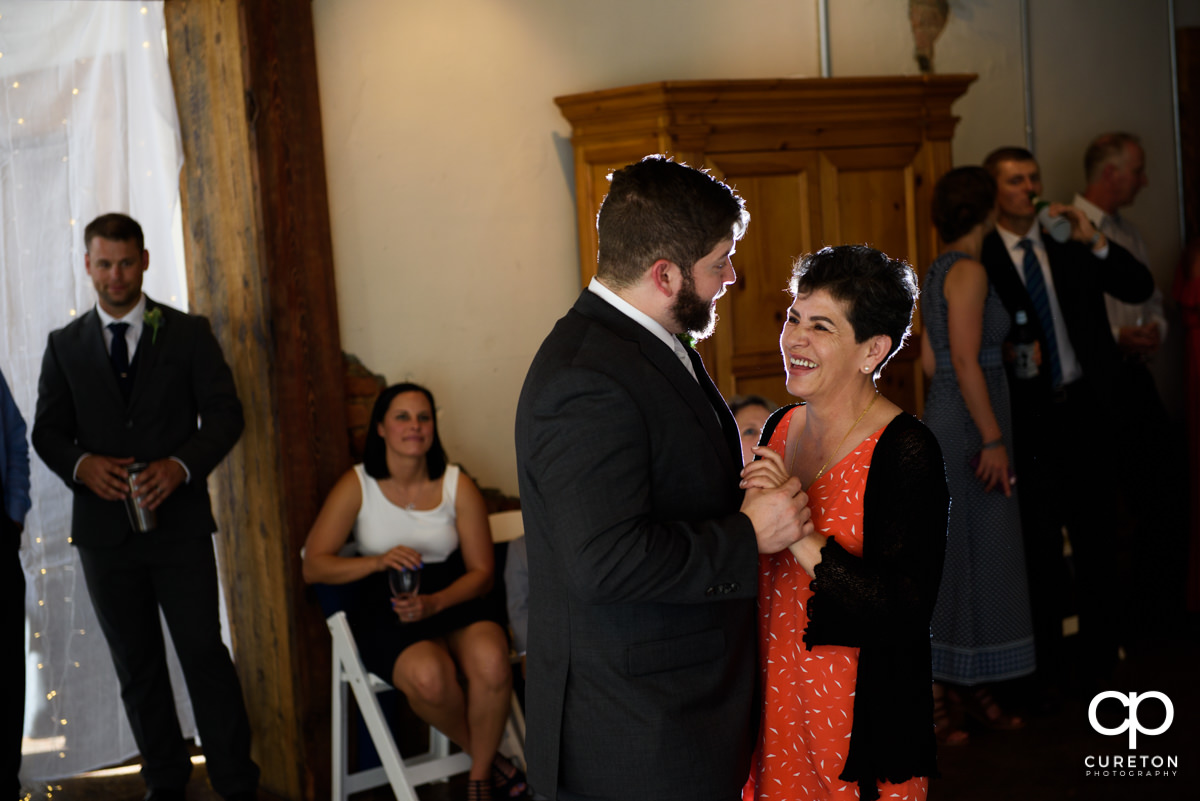 Groom's mother laughing during their first dance.