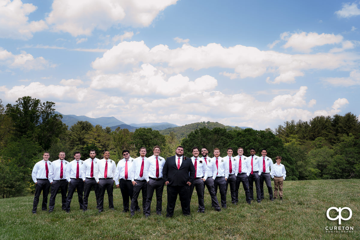 Groom and groomsmen in front of a mountain overlook in a field in Asheville,NC.