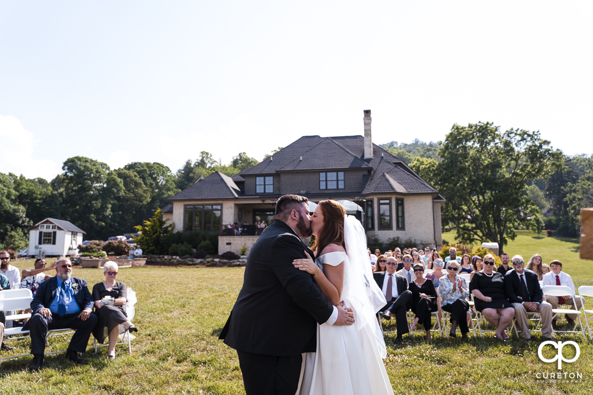 The first kiss during the outdoor wedding ceremony in Asheville,NC.