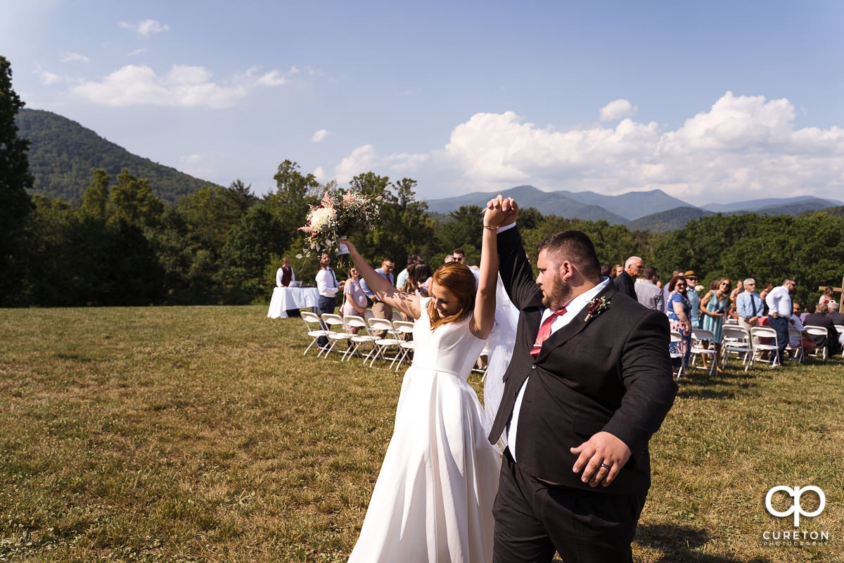 Bride and groom celebrating their vows during the outdoor wedding ceremony in Asheville,NC.