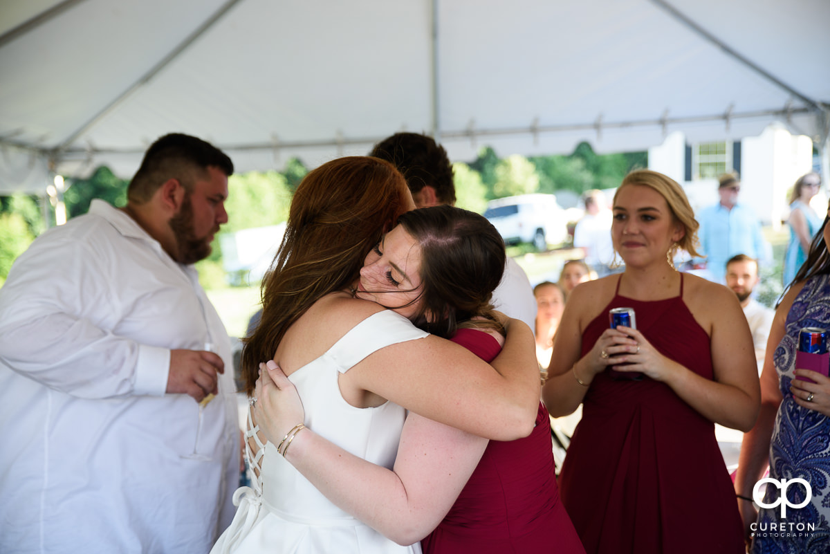 Bride hugging a bridesmaid.