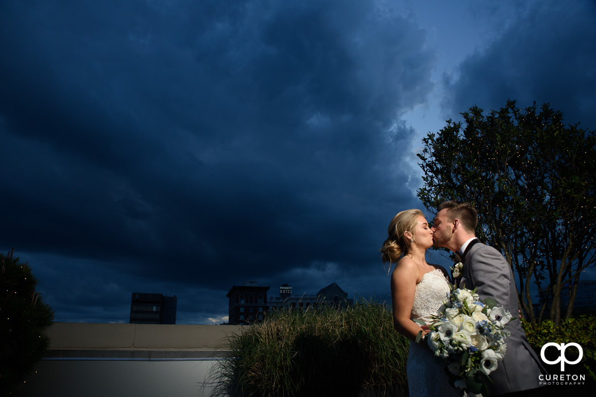 Bride and groom kissing at sunset during their wedding reception at Avenue in Greenville,SC.