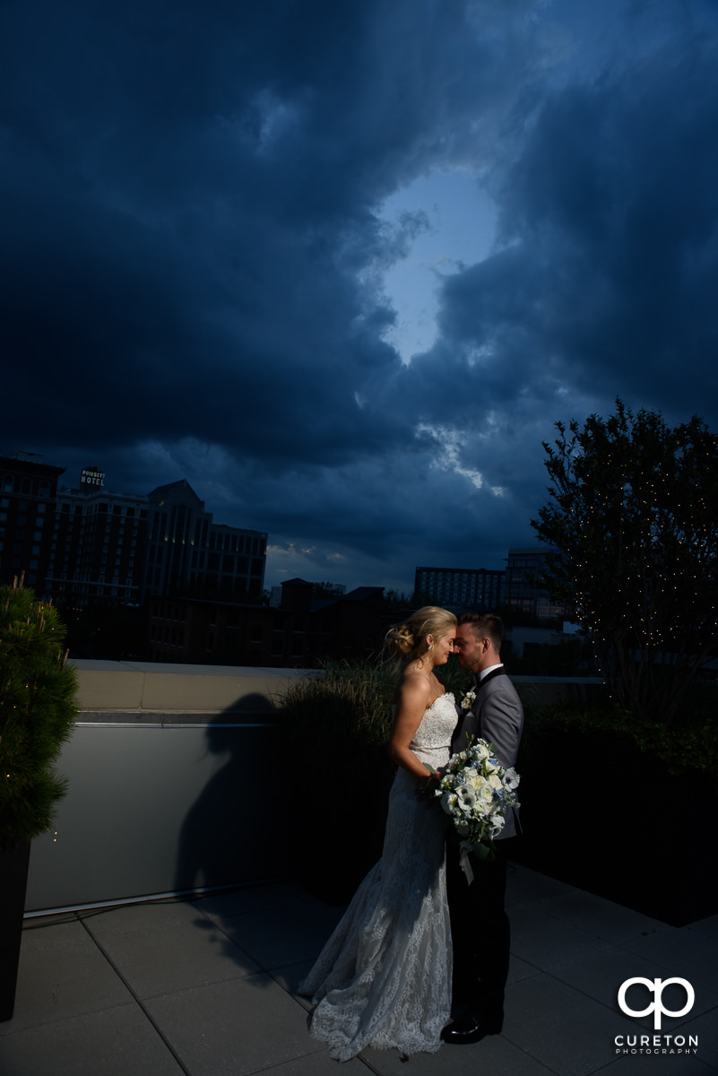 Bride and groom snuggling on a rooftop at sunset in downtown Greenville ,SC.
