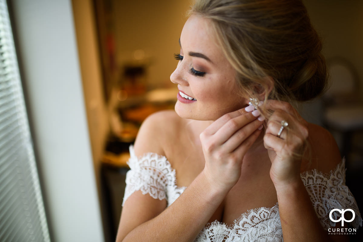Bride putting on her earrings.