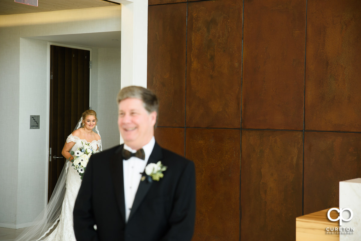 Bride walking up during first look with her father at Avenue in Greenville,SC.