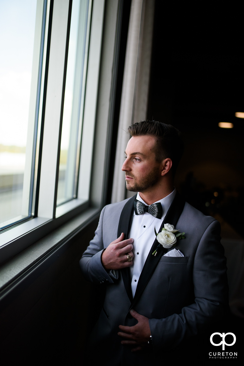 Groom looking out the window at Avenue Greenville.