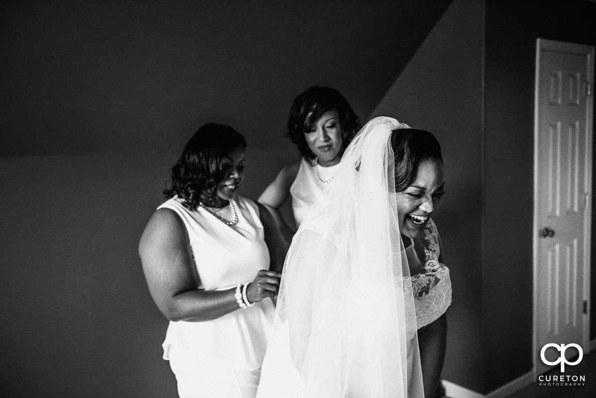 Bride laughing while getting ready for her wedding day.