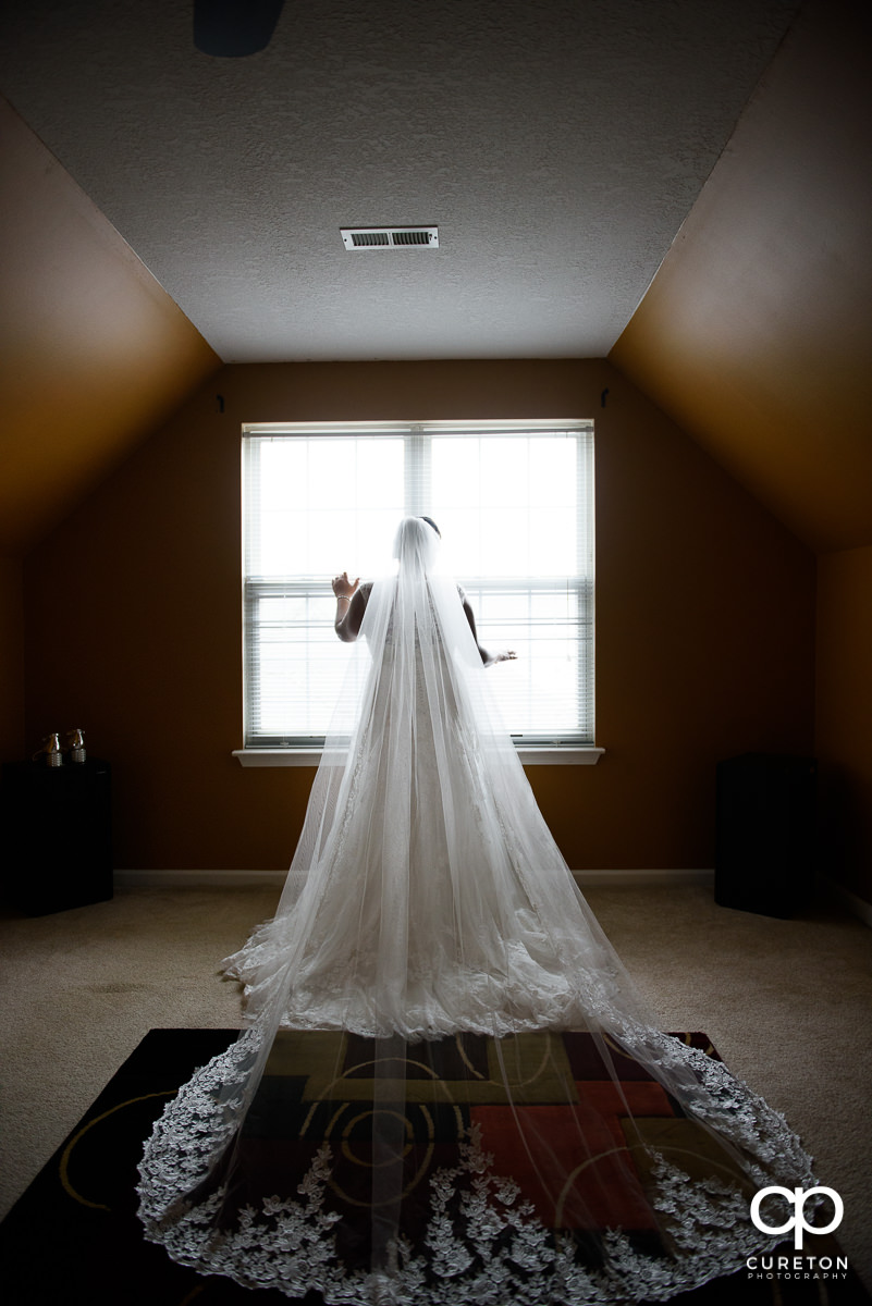Bride standing in a window.