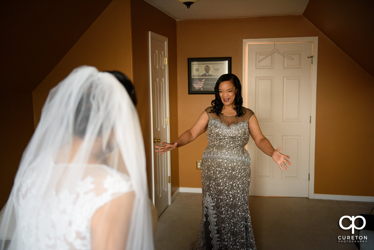 Bride's mom seeing her daughter in the dress on her wedding day.