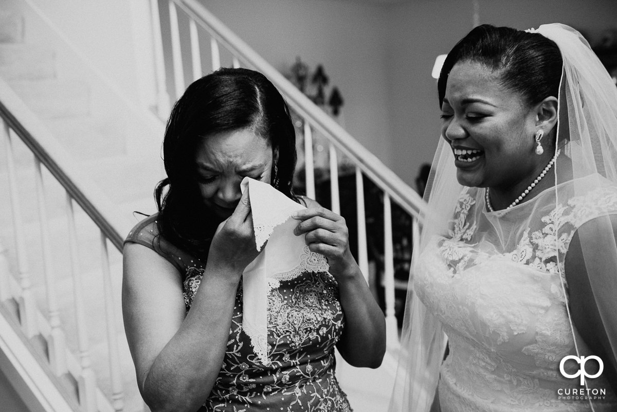 Bride's mom tearing up while receiving a gift from her daughter.
