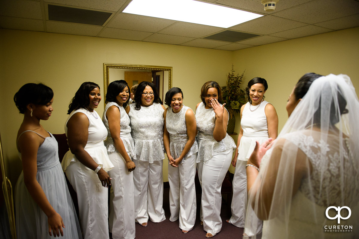 Bridesmaids seeing the bride in her dress for the first time.