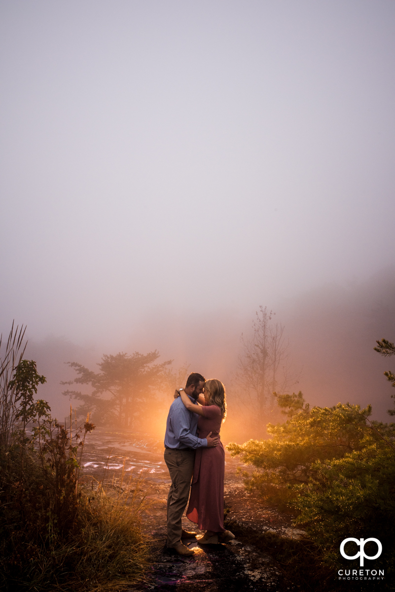 Future bride and groom dancing in the fog during an engagement session at Bald Rock.