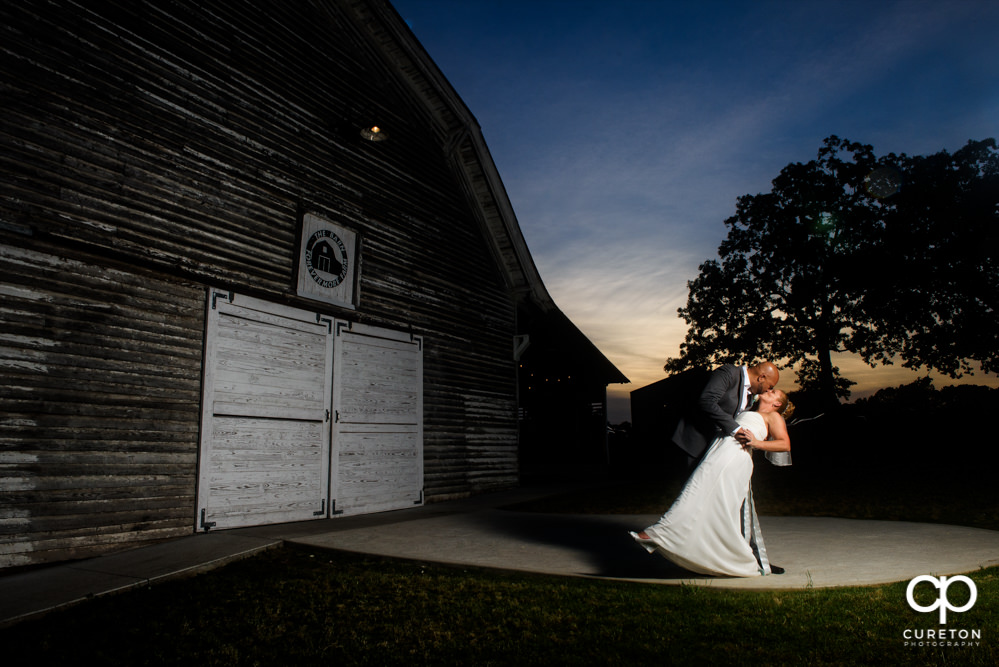 Bride and groom kissing at the Barn at Forevermore Farms after their rustic wedding.