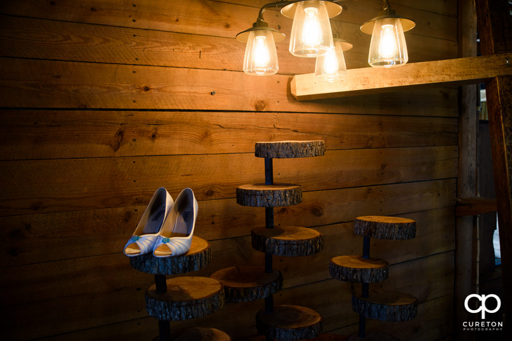 Bride's shoes under Edison light bulbs.