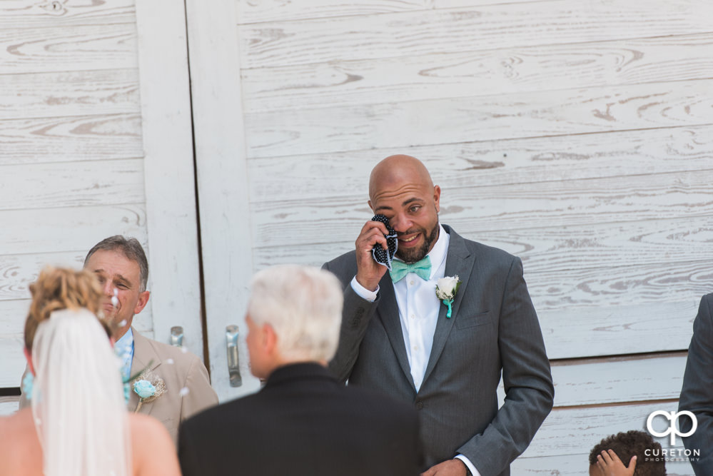 Groom crying when he's sees his bride walking down the aisle.
