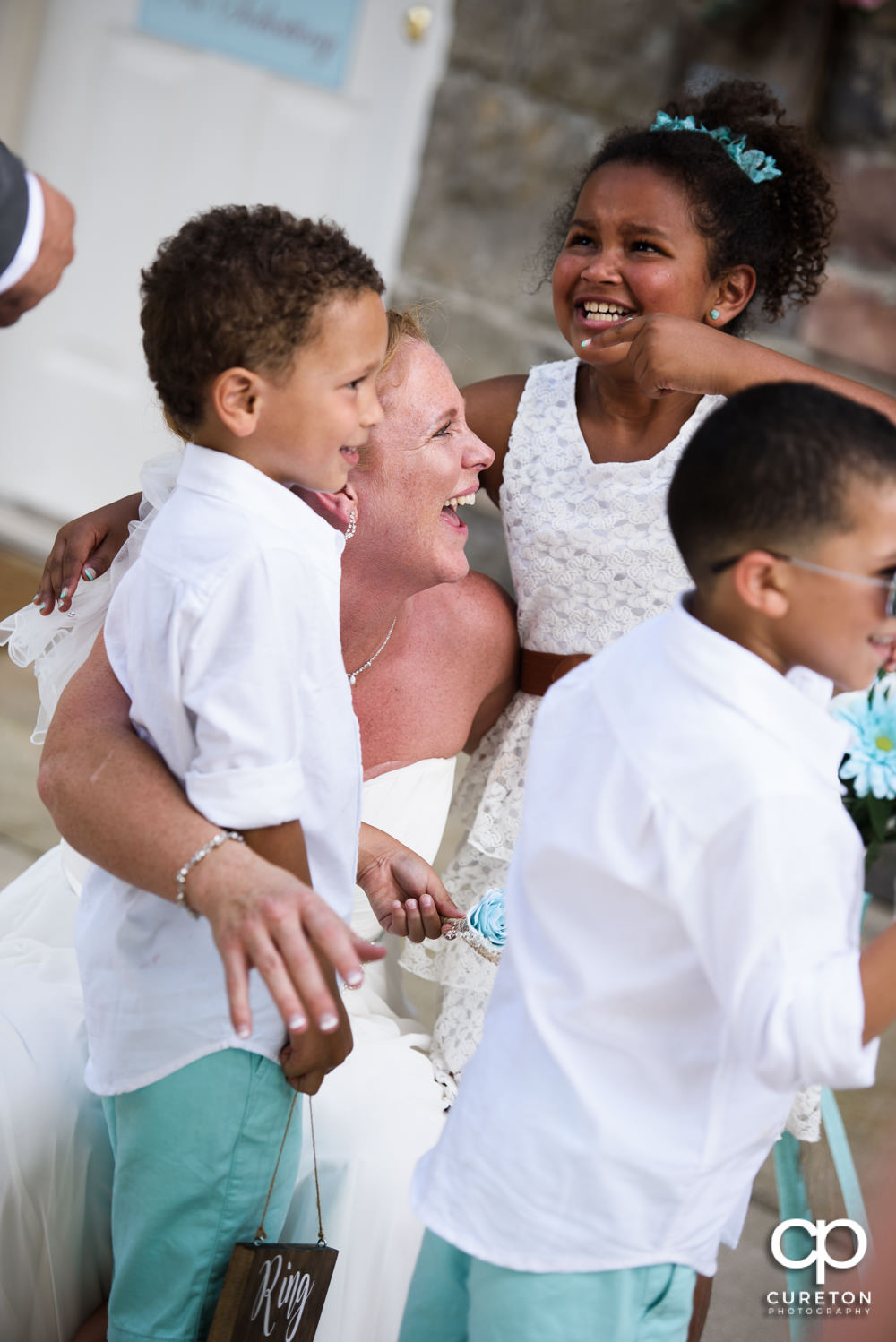 Bride and groom celebrating with their children after their wedding.