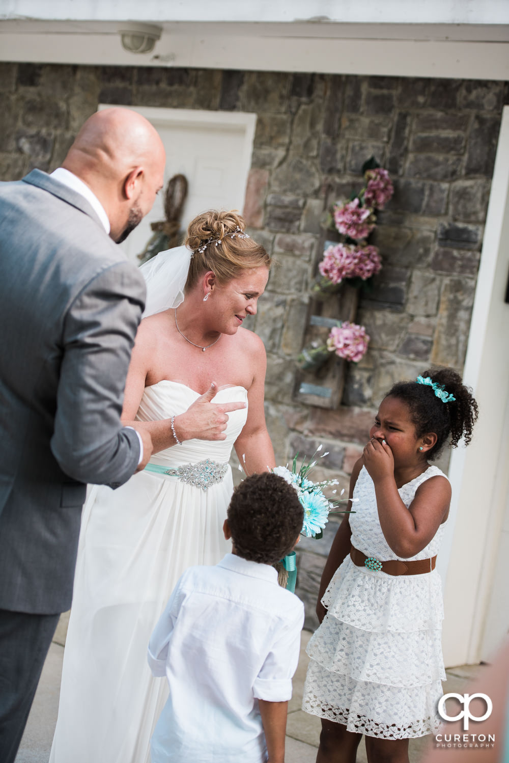 Bride and groom celebrating with their children after their wedding.
