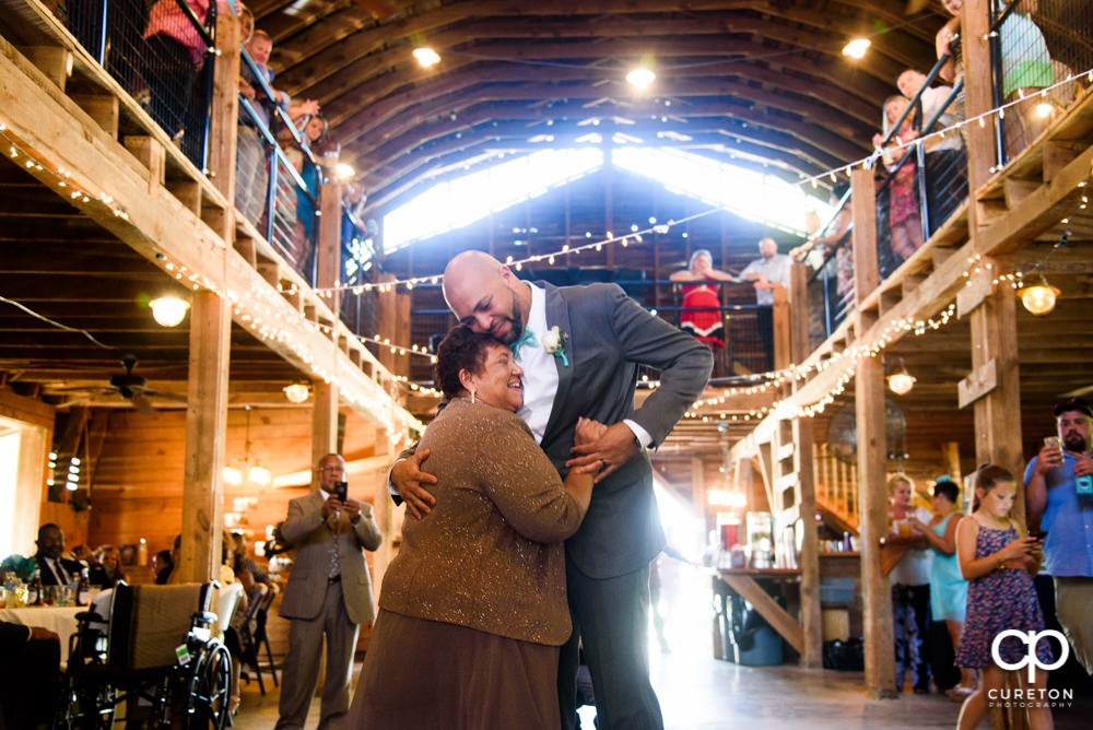 Groom and mother dance at their wedding reception at The Barn at Forevermore Farms.