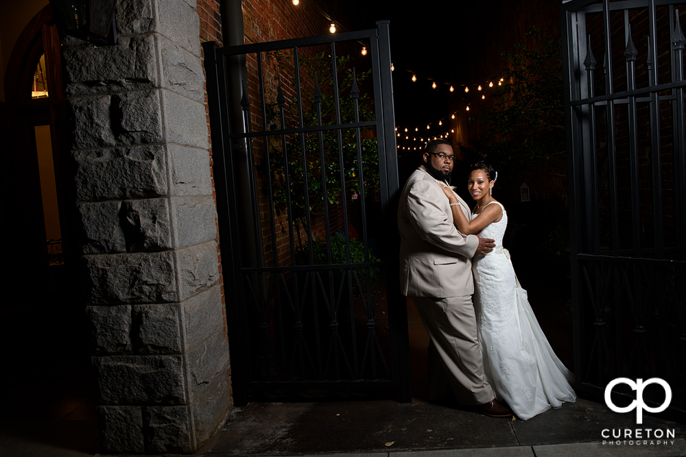 Bride and groom by an iron gate after their wedding at the Bleckley Inn in Anderson,SC.