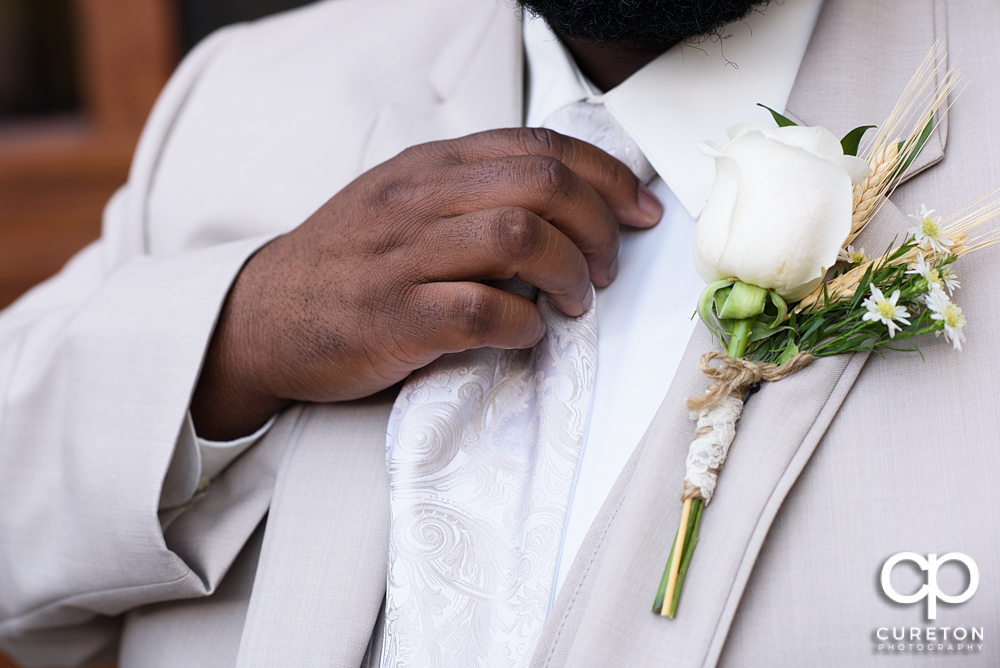 Groom straightening his tie.