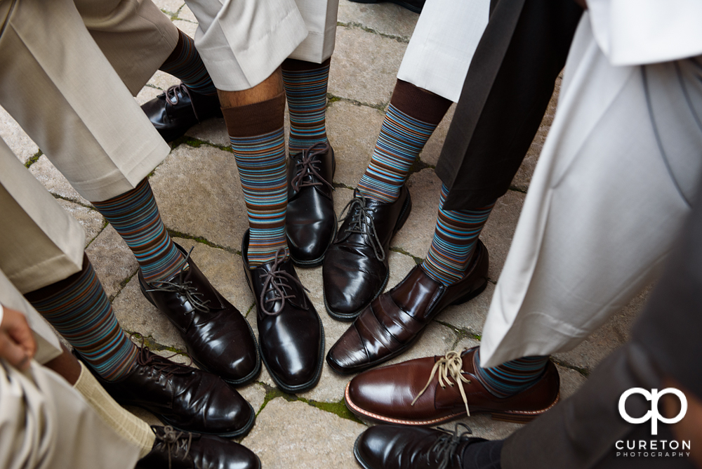 The groomsmen all showing off their matching socks.