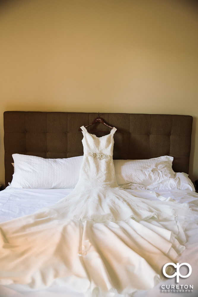 The bride's dress laying on the bed.