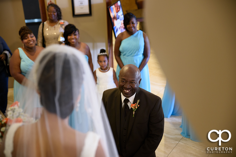 Bride's father smiling at her during the first look.