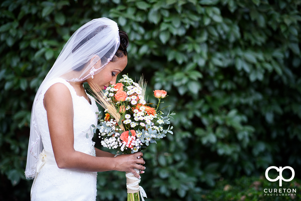 Bride smelling her flowers.