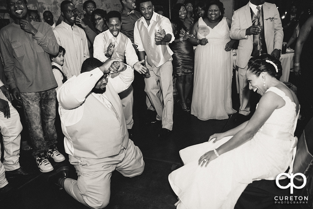 Groom taking off the garter.