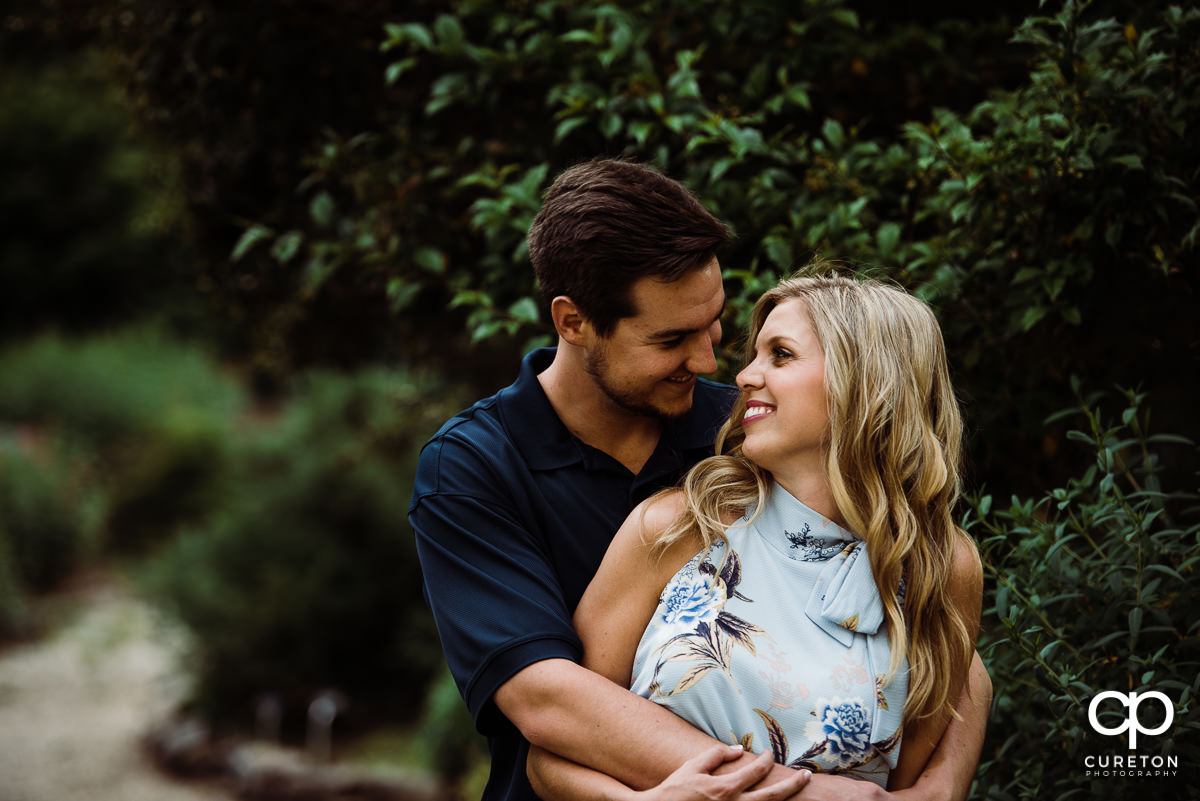 Engaged couple smiling at each other during their Botanical Gardens engagement session in Clemson,SC.