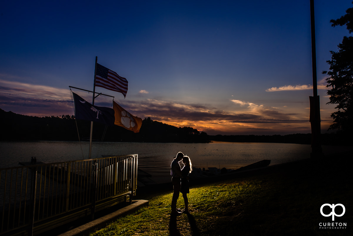 Epic engagement shot of a couple by the lake in Clemson at sunset.